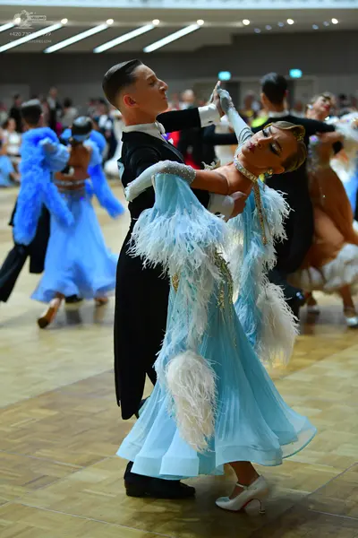 Dancesport competitor: Male dancer (foreground): black tailcoat suit with a white shirt and black trous