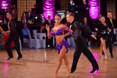 Dancesport competitor: Male dancer (left): black long-sleeved shirt and black trousers
