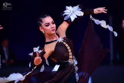 Dancesport competitor: Female dancer: dark brown latin dress with a sequined bodice, cutout details, an