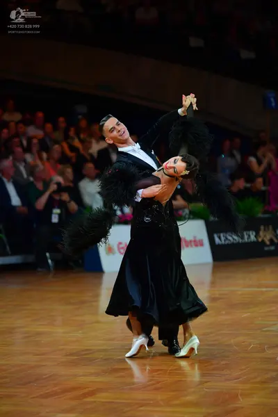 Dancesport competitor: Male dancer: black tuxedo jacket with a white shirt and white bowtie