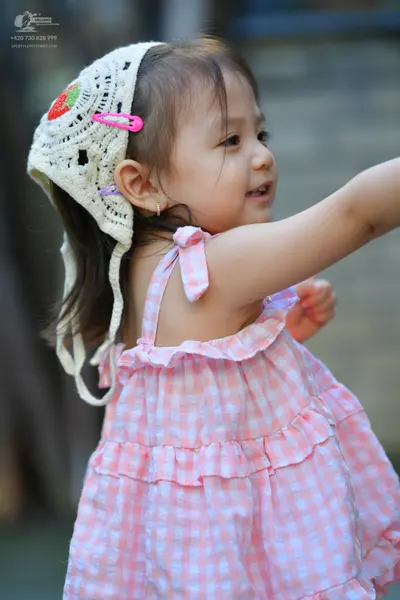 Dancesport competitor: Female dancer: pink and white gingham patterned dress with ruffles and a white c