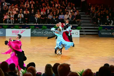 Dancesport competitor: Female dancer (left): bright pink latin dress with flowing, lightweight fabric