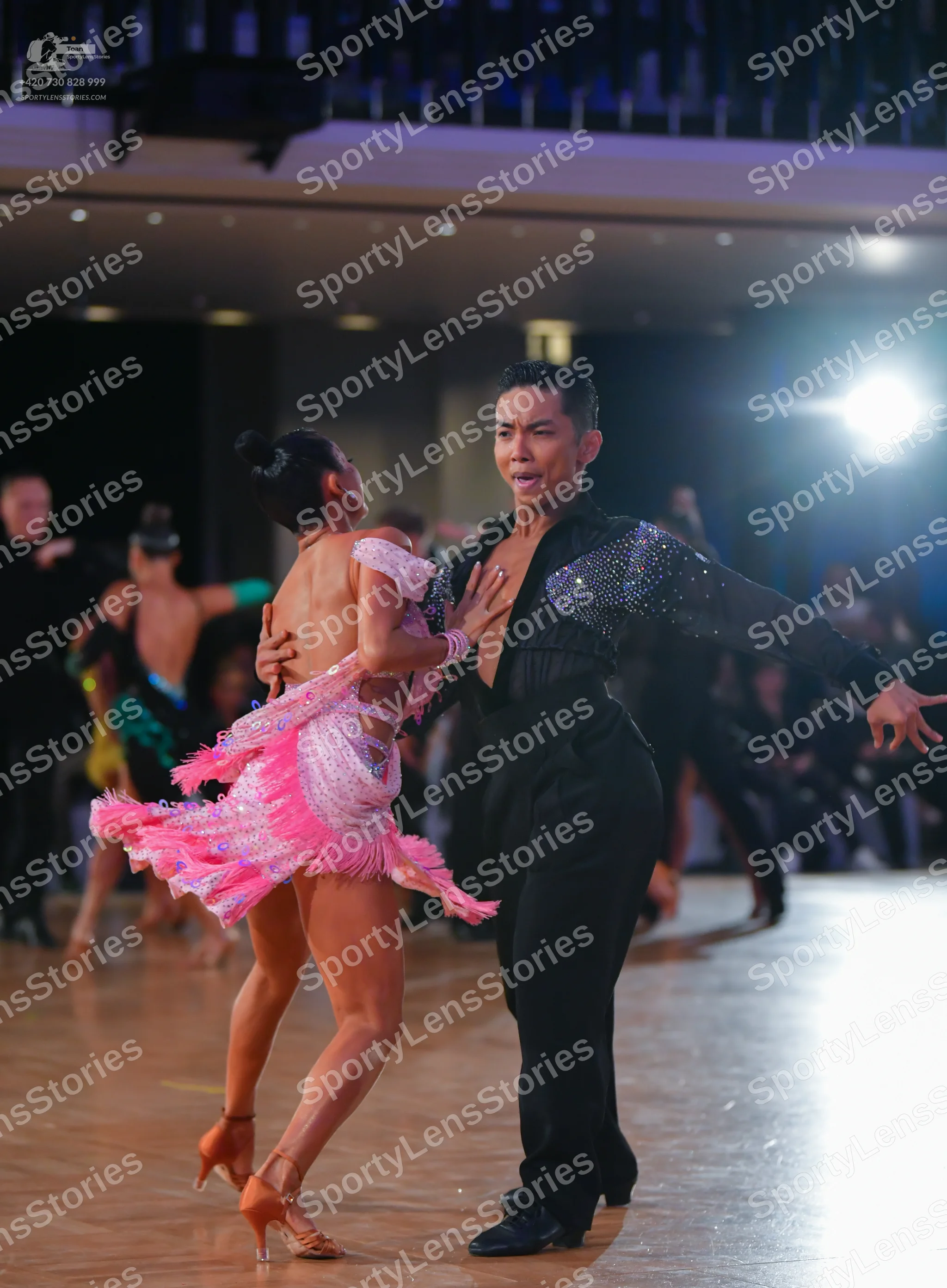 Dancesport competitor: Female dancer: light pink Latin dress with a sequined bodice and layered pink fr