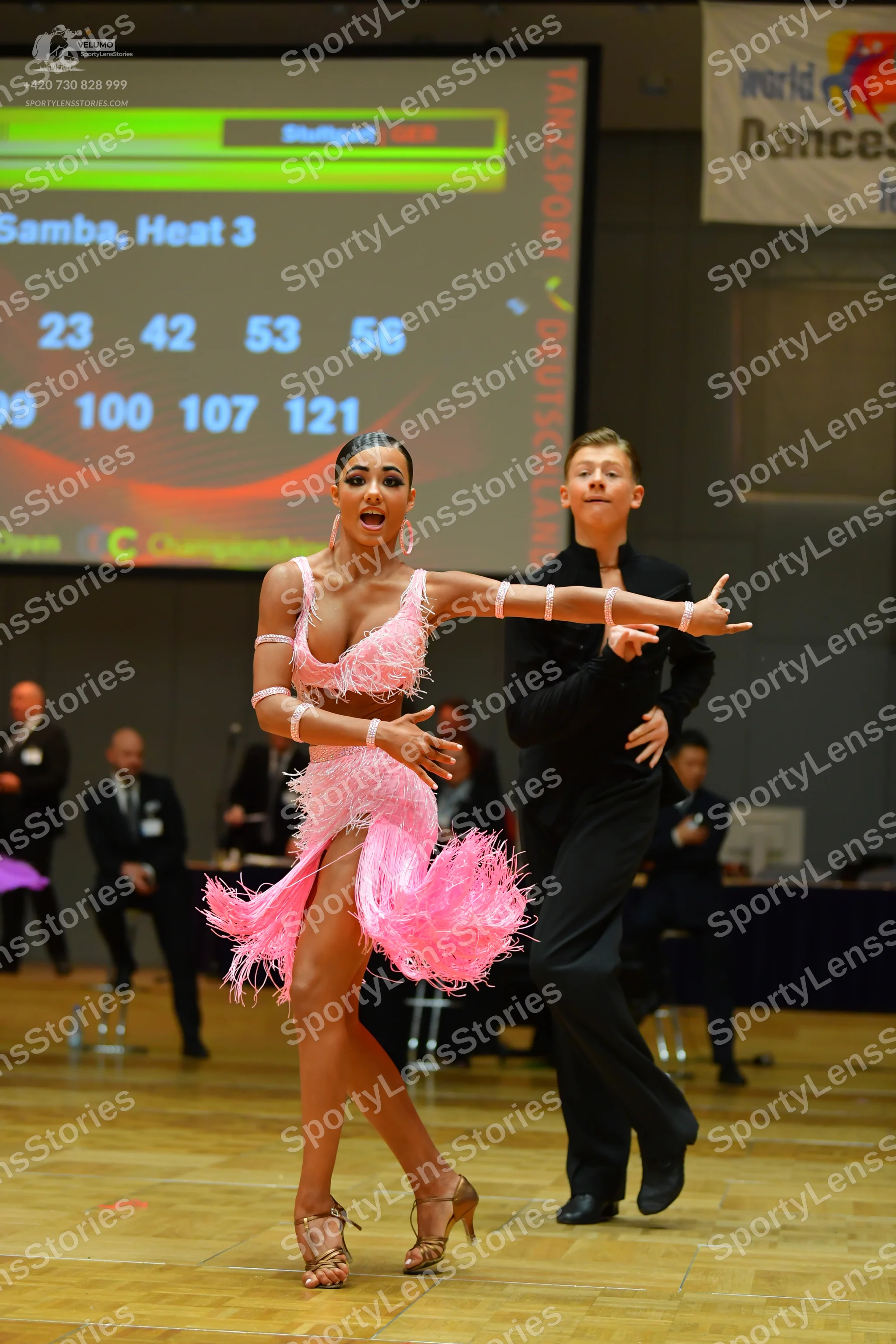 Dancesport competitor: Female dancer: pink latin dress with long fringe and armbands