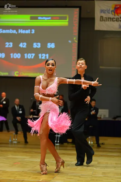 Dancesport competitor: Female dancer: pink latin dress with long fringe and armbands