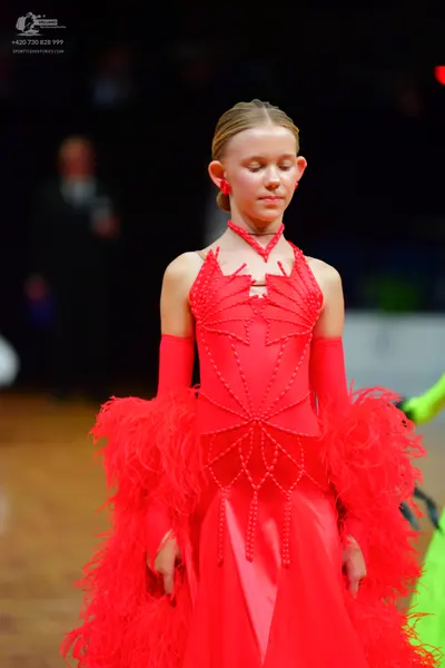 Dancesport competitor: Female dancer: bright red Latin dance dress with intricate beadwork on the bodic