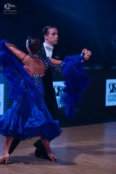Dancesport competitor: Male dancer: black tuxedo with a white shirt and white bow tie