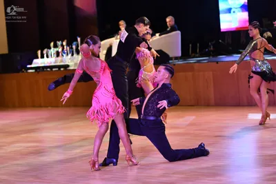 Dancesport competitor: Female dancer in foreground: pink latin dress with fringe