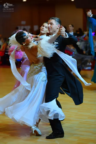 Dancesport competitor: Female dancer: white ballgown with a heavily sequined bodice, a voluminous flowi