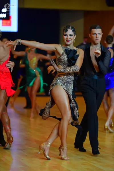Dancesport competitor: Female dancer (center): leopard print Latin dress with a high slit and a matchin