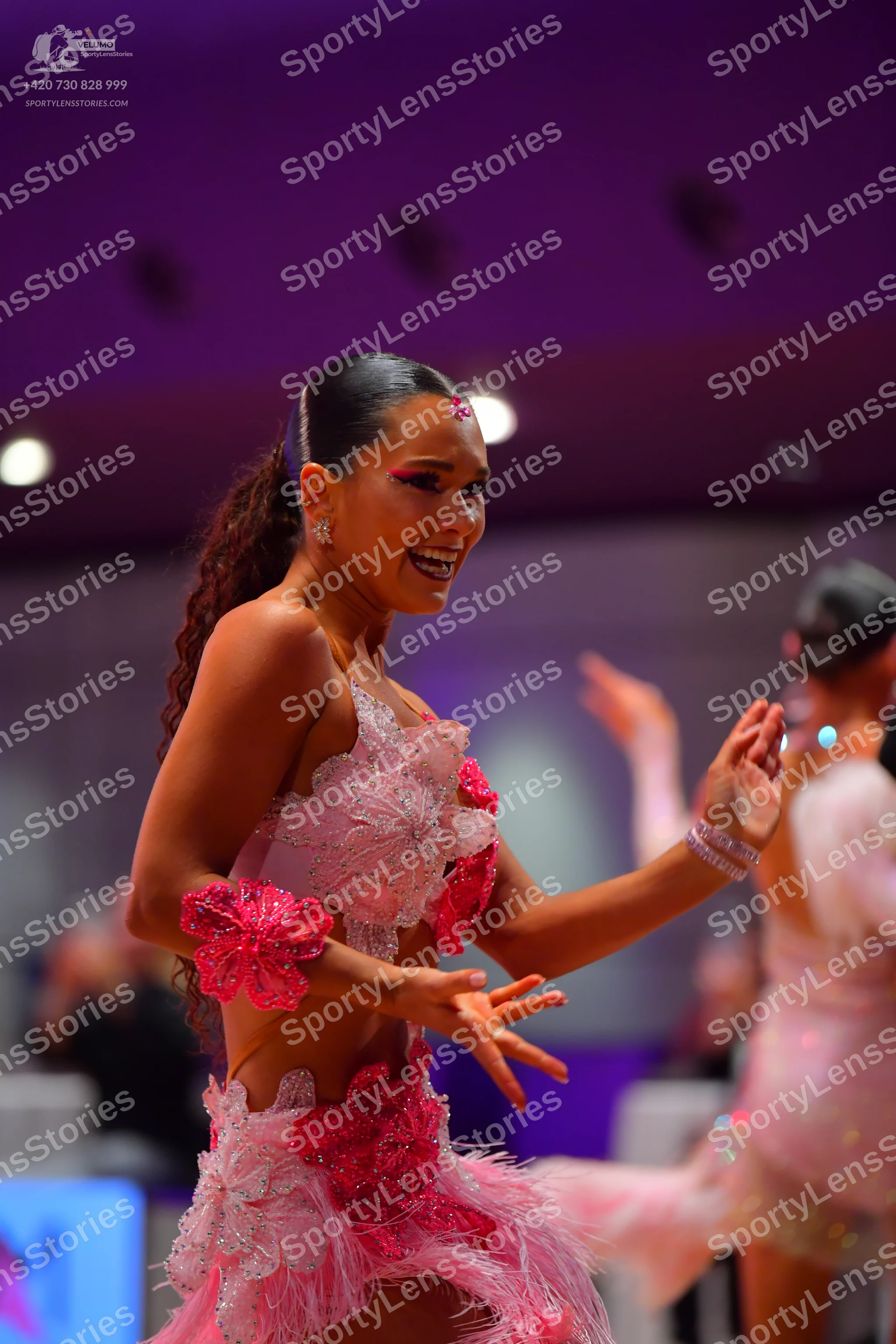 Dancesport competitor: Female dancer: pink Latin dance dress with floral lace appliqués, a skirt with p