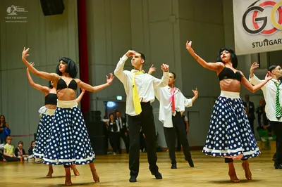 Dancesport competitor: Female dancers: black bra tops with white waistbands and dark blue skirts with w