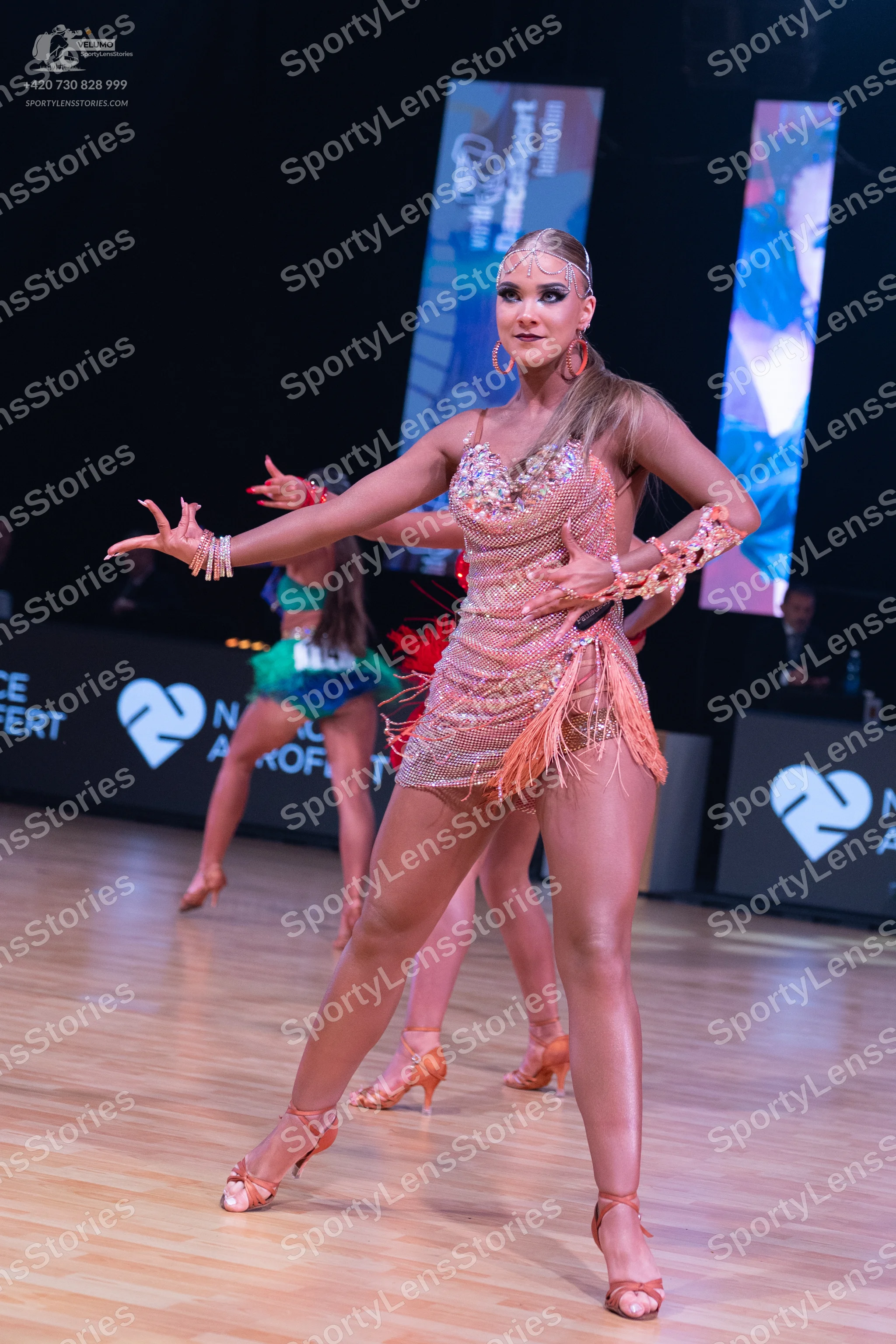 Dancesport competitor: Front female dancer: champagne-colored Latin dance dress with sequins, rhineston