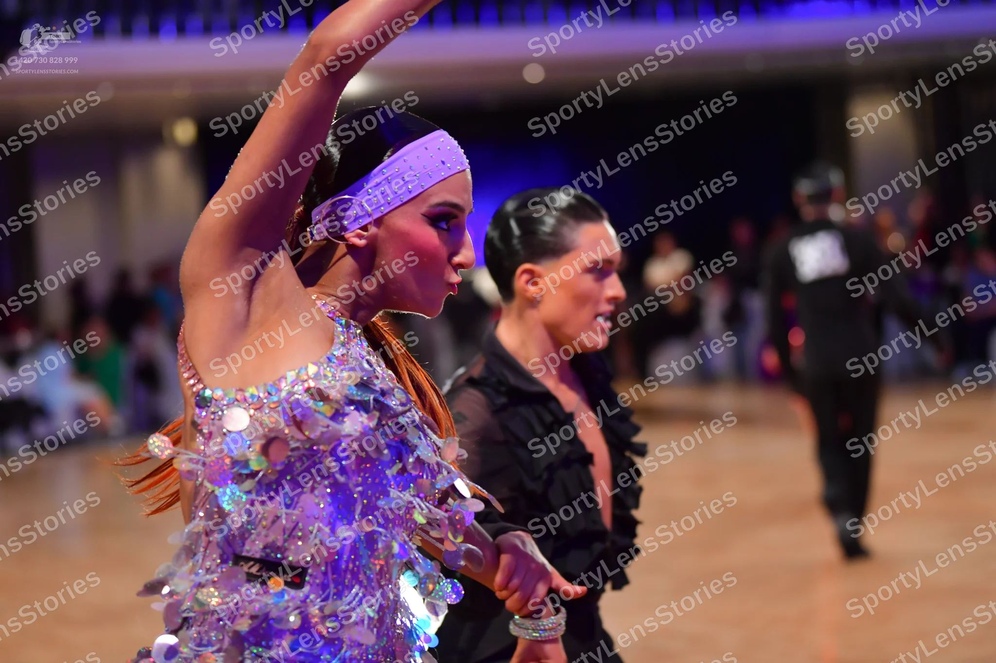 Dancesport competitor: Female dancer: light lavender Latin dress heavily embellished with large, irides
