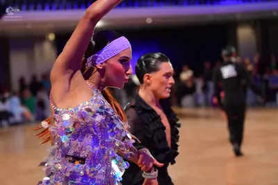 Dancesport competitor: Female dancer: light lavender Latin dress heavily embellished with large, irides
