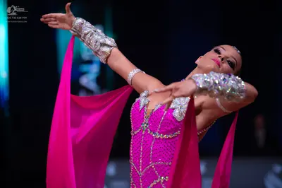 Dancesport competitor: Female dancer: pink latin dance dress decorated with silver sequins and crystals