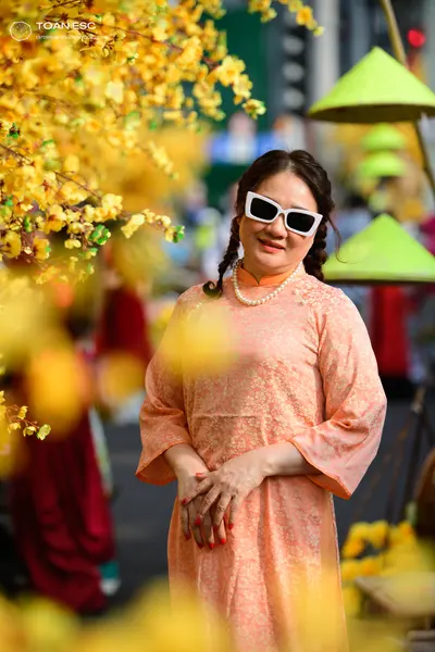 Dancesport competitor: Female dancer: peach-colored patterned dress with long sleeves, wearing a pearl 