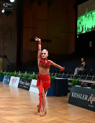 Dancesport competitor: Female dancer: red Latin dress with large red fabric flowers on the bust and red