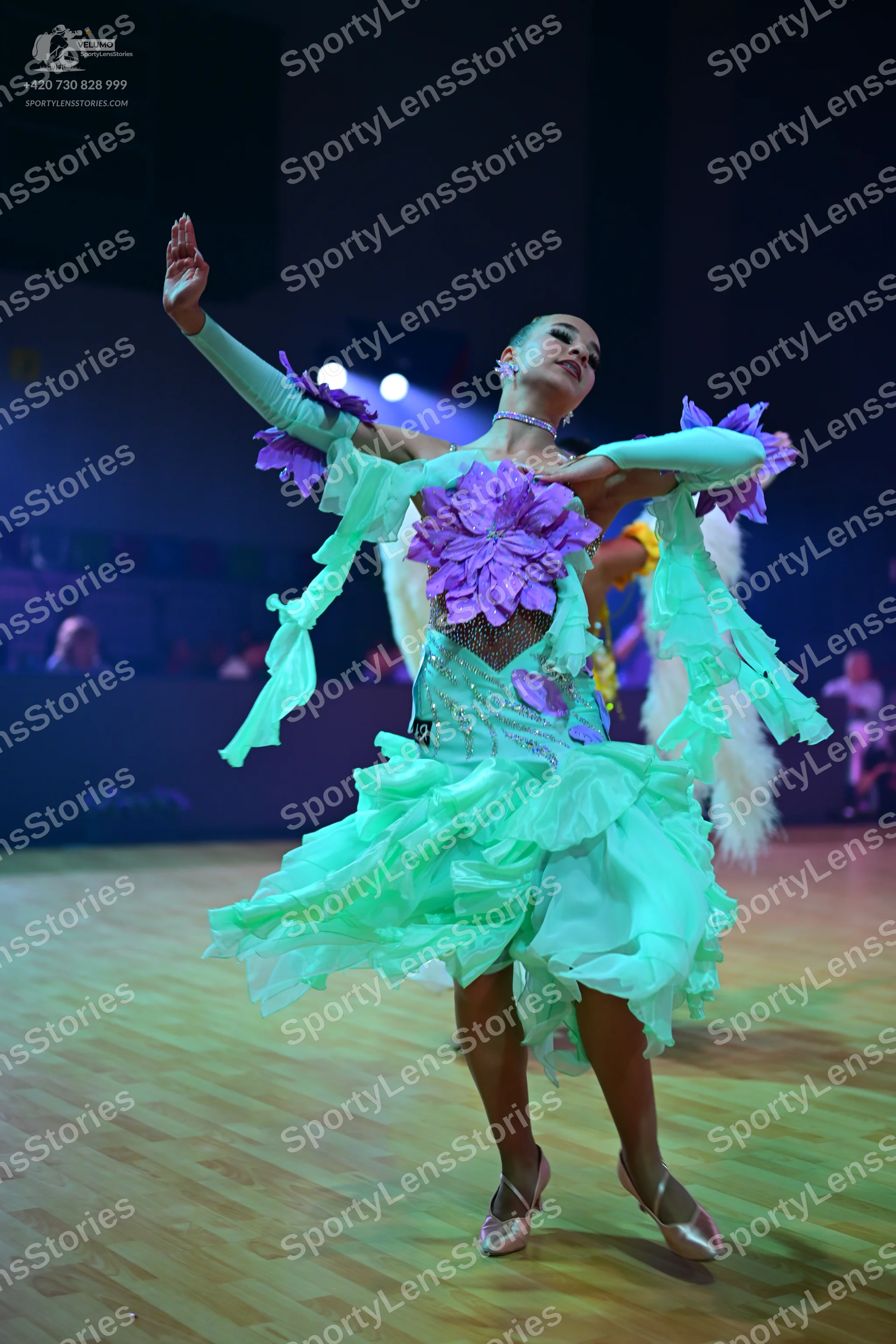 Dancesport competitor: Female dancer: mint green Latin dress with large purple fabric flowers, ruffles,