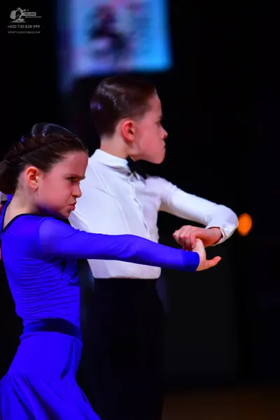 Dancesport competitor: Female dancer: royal blue long-sleeved dress with a black waistband