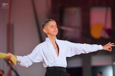 Dancesport competitor: Male dancer: white long-sleeved shirt with a deep V-neck and pleated front, blac
