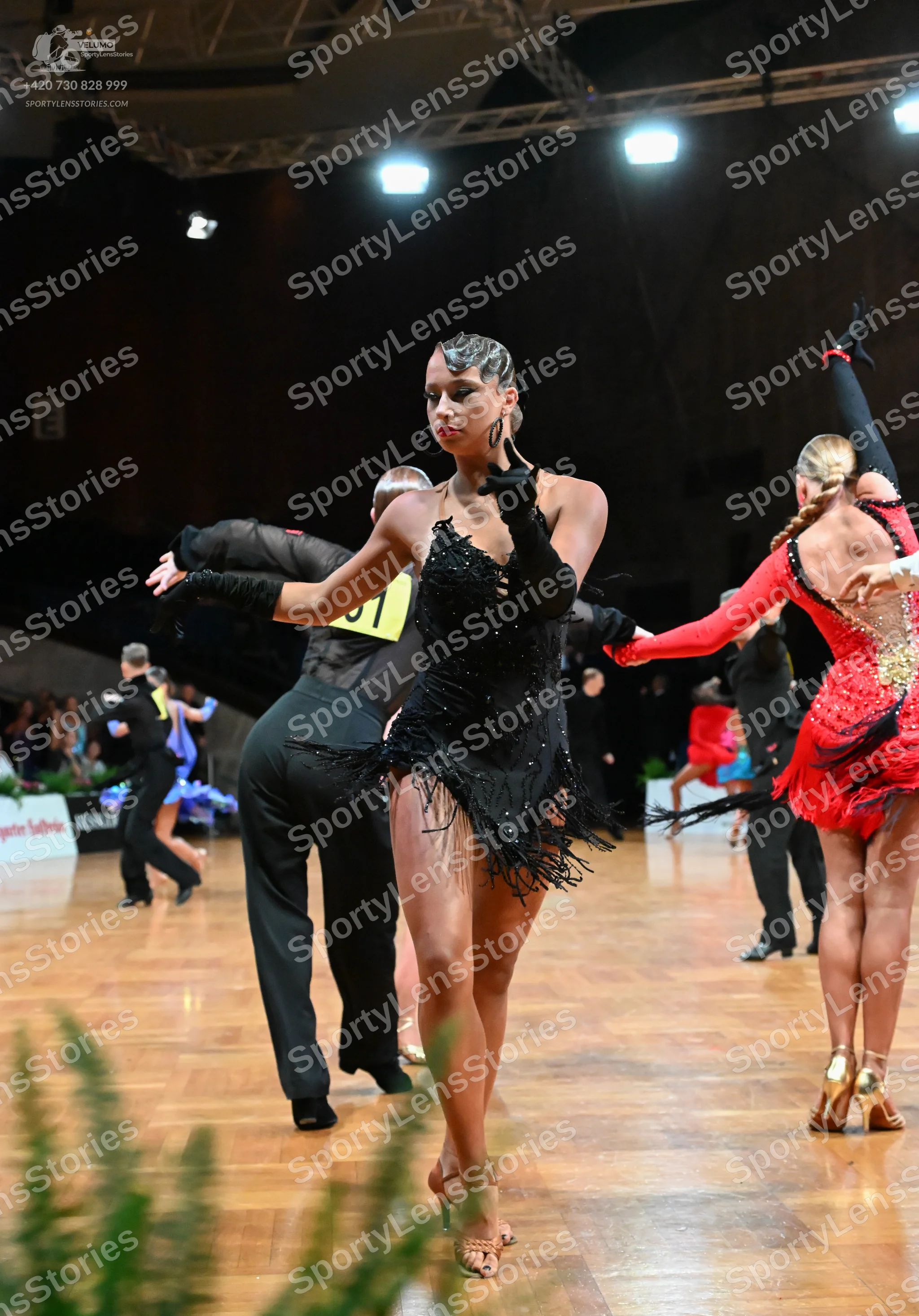 Dancesport competitor #71: Female dancer in center: black latin dress with sequins and fringe, black long g