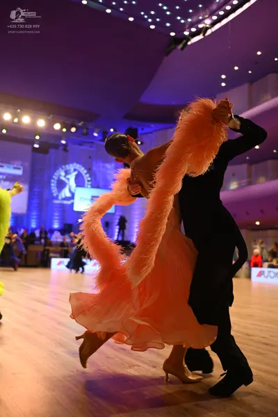 Dancesport competitor: Female dancer: peach-colored ballroom dress with voluminous, feathery or fringed