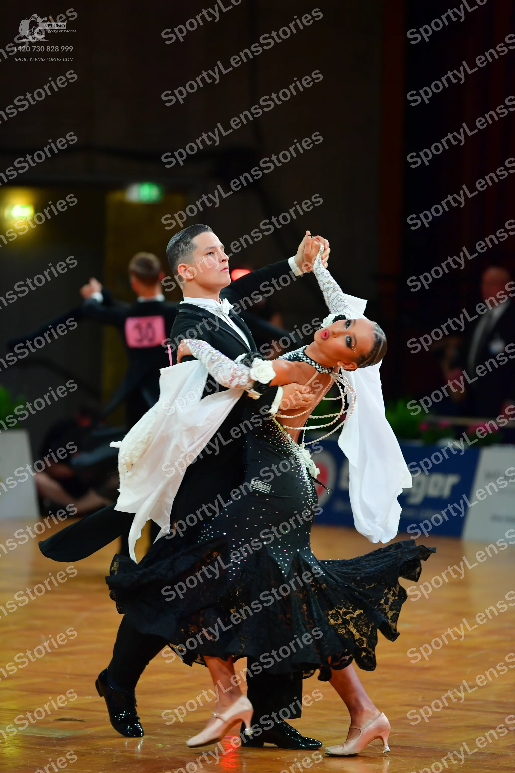 Dancesport competitor: Male dancer: black ballroom tailcoat with white ruffled cuffs and black trousers