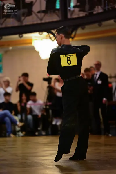 Dancesport competitor: Male dancer: black long-sleeved shirt and black trousers