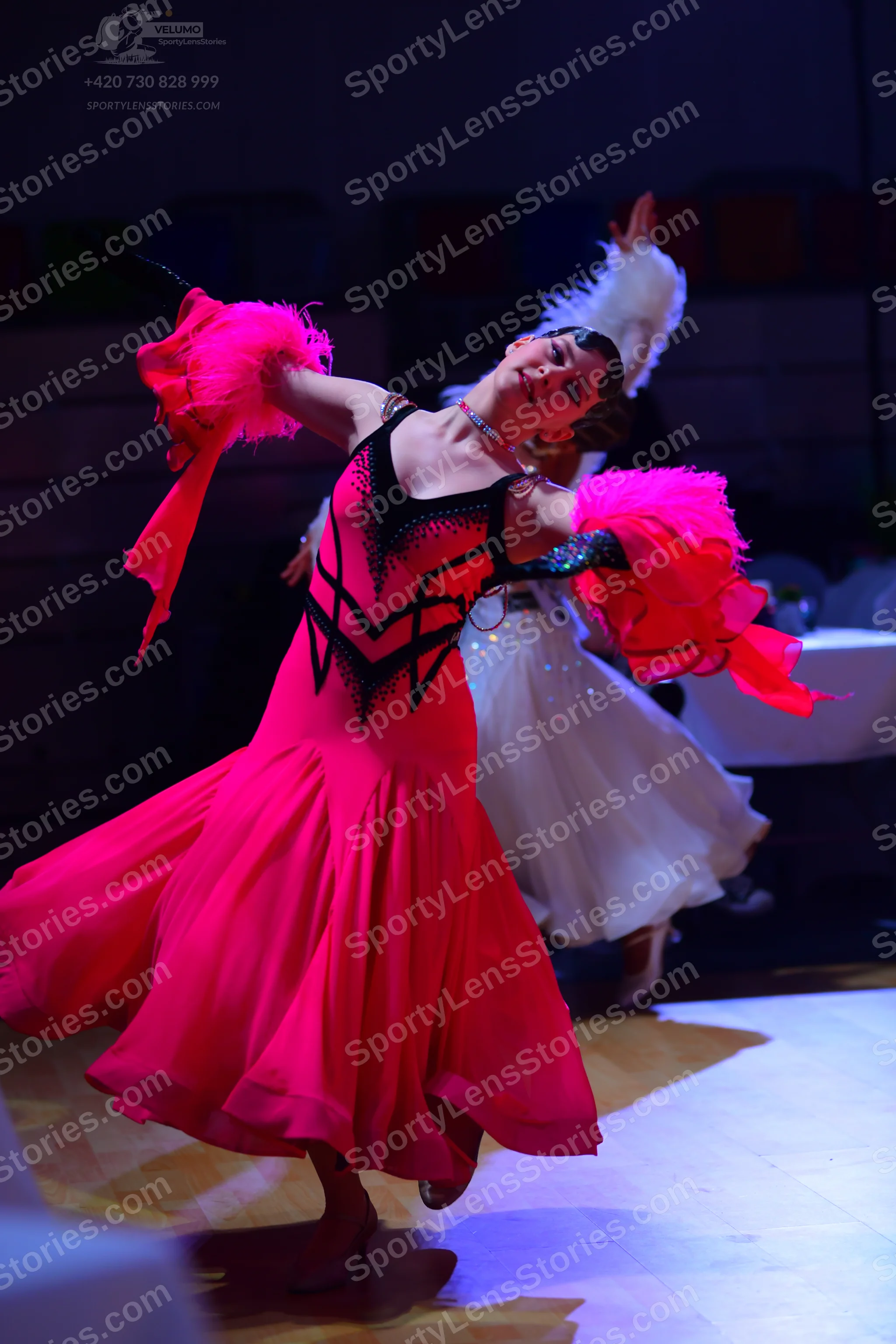 Dancesport competitor: Female dancer 1: bright pink Latin dress with black sequin V-shaped pattern on t