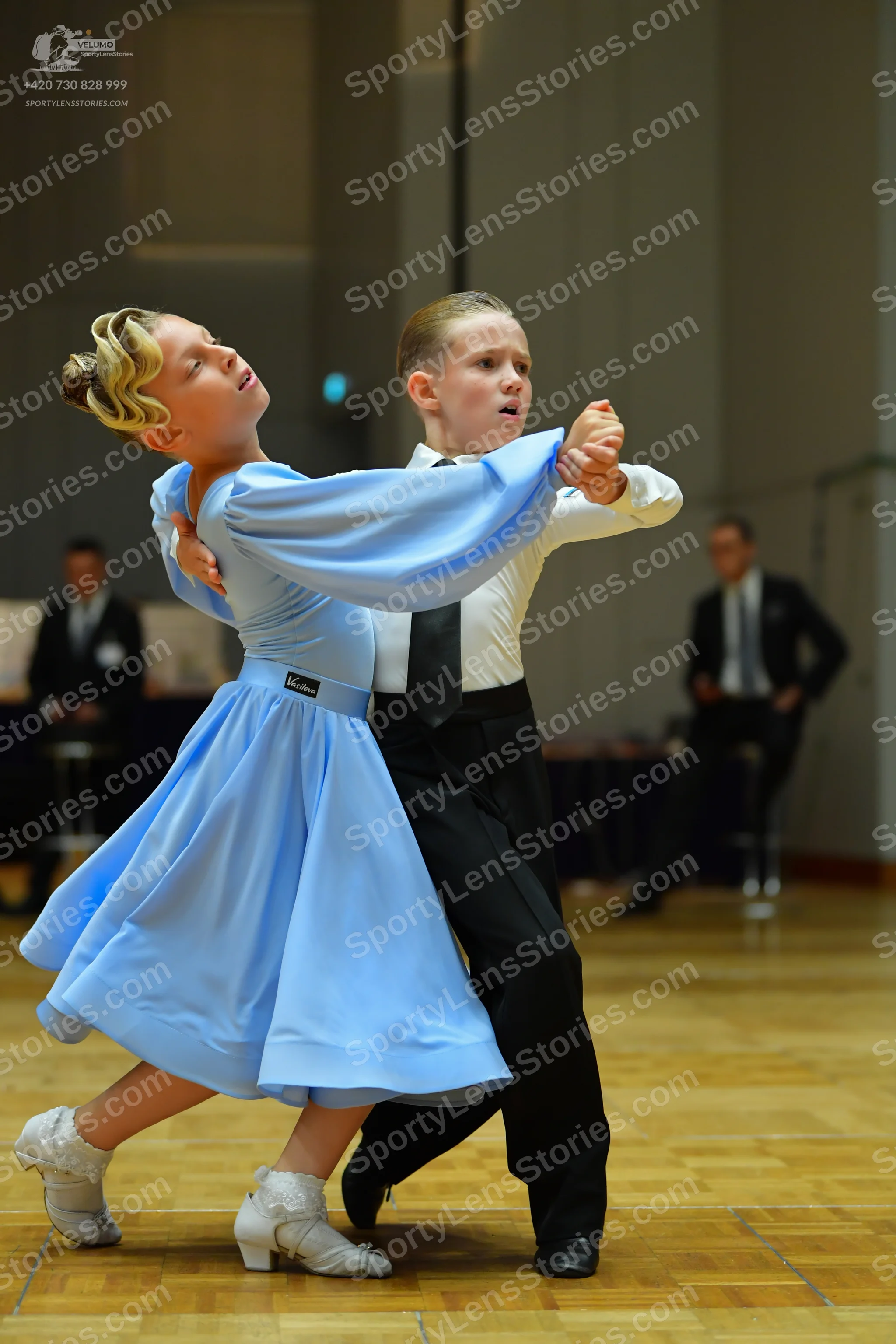 Dancesport competitor: Female dancer: light blue, long-sleeved satin ballgown