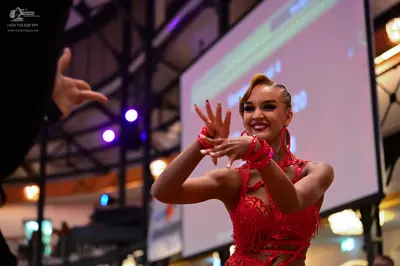 Dancesport competitor: Female dancer: red Latin dance dress with sequins and cutout details, matching r