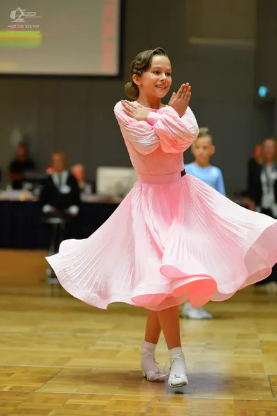Dancesport competitor: Female dancer: light pink long-sleeved dress with a pleated skirt