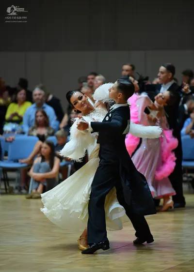 Dancesport competitor: Male dancer (foreground): black suit with a white shirt and black bow tie
