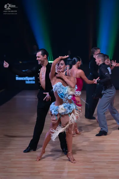 Dancesport competitor: Male dancer (front): black long-sleeved latin dance shirt and black trousers