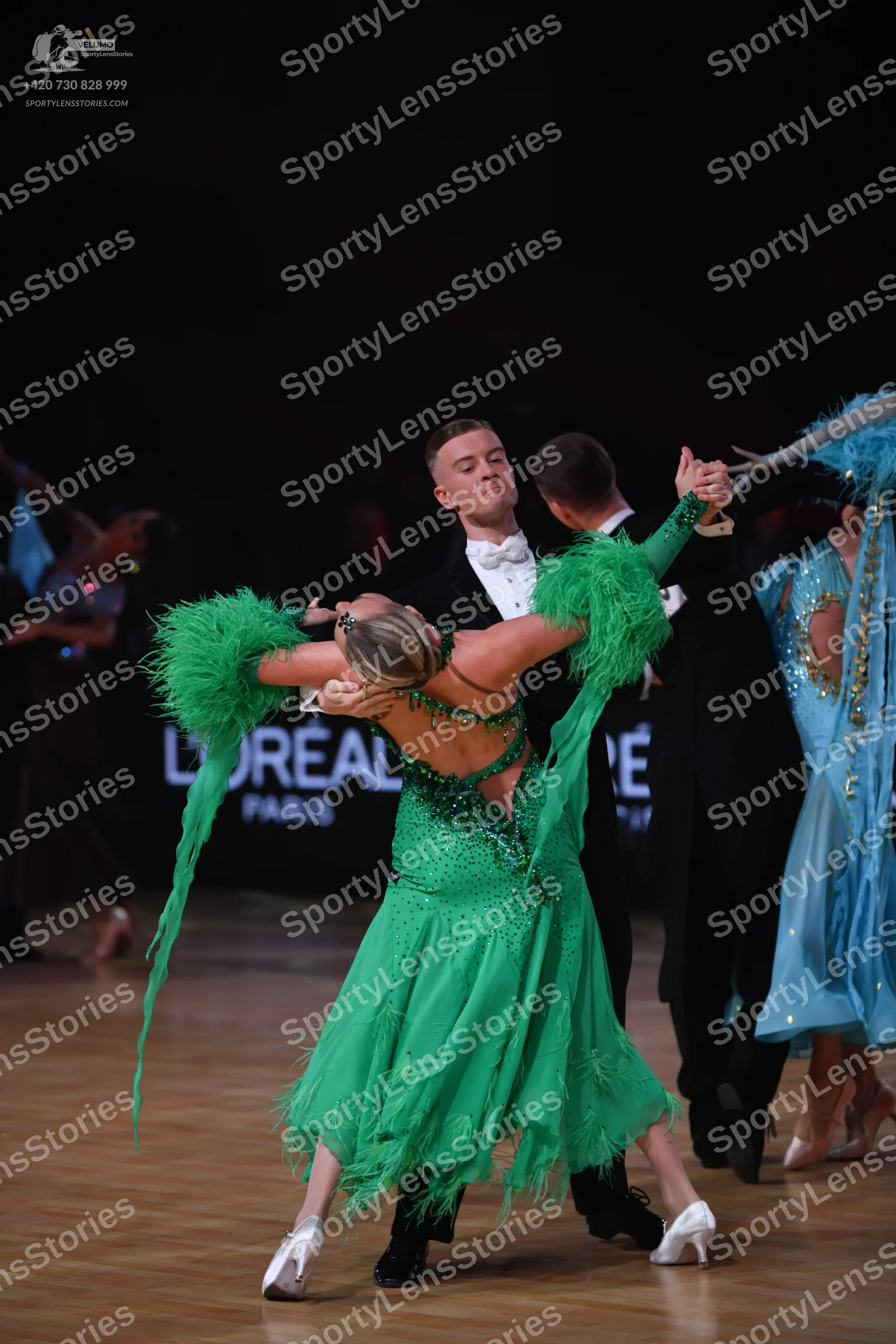 Dancesport competitor: Female dancer (foreground): emerald green dance dress with heavy sequin and crys