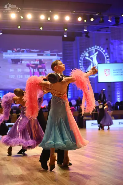 Dancesport competitor: Main female dancer: light blue and pink ballroom gown with large pink feather-li