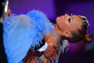 Dancesport competitor: Female dancer: light blue Latin dance costume with feather-like fringe embellish