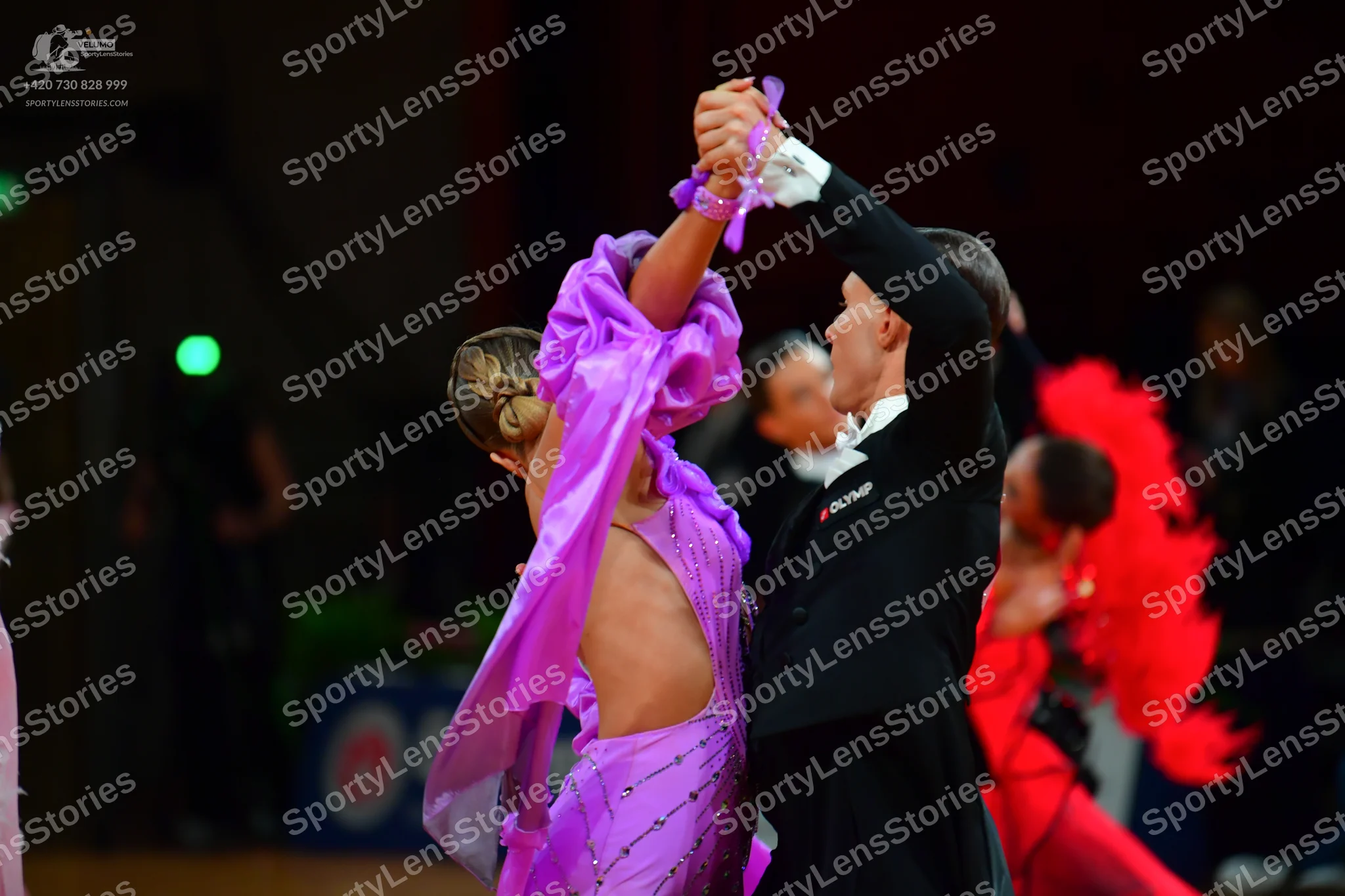 Dancesport competitor: Main female dancer: lavender Latin dress decorated with rhinestones and featurin