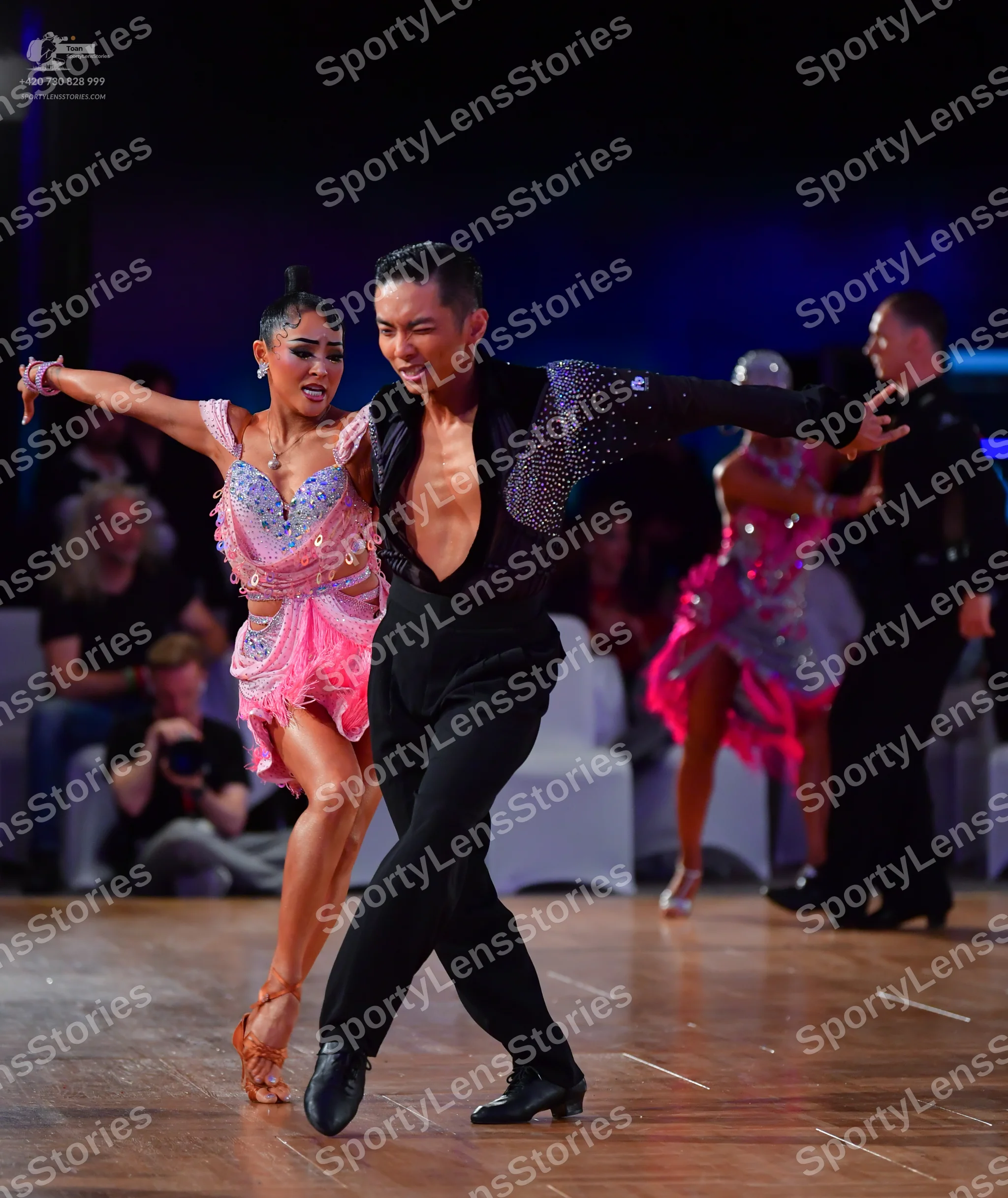 Dancesport competitor: Foreground male dancer: black latin dance shirt with silver sequined sleeves and