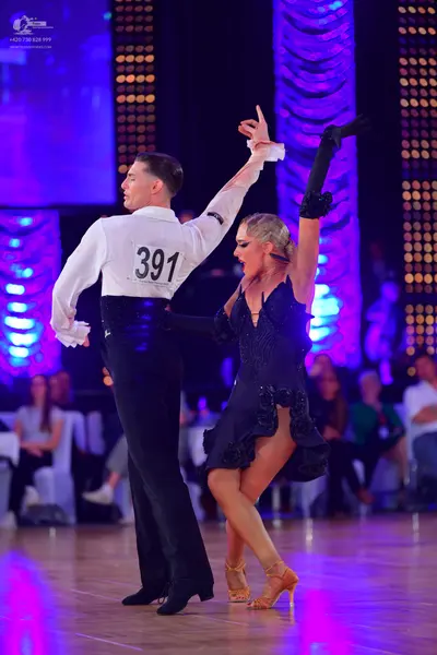 Dancesport competitor #391: Male dancer: white long-sleeved shirt with ruffled cuffs, black trousers, and a 