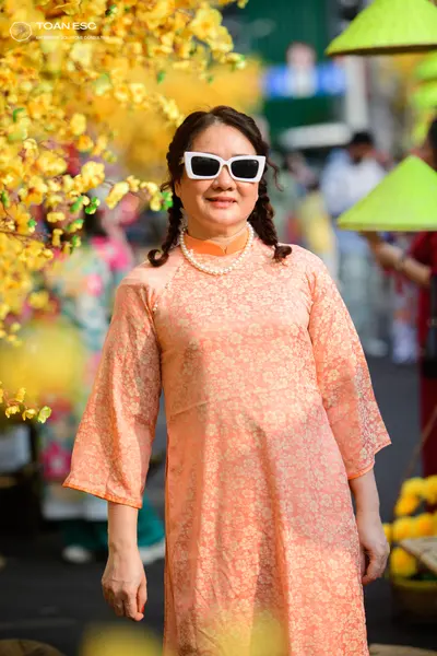 Dancesport competitor: Female dancer: peach-colored, long-sleeved dress with a subtle patterned fabric,