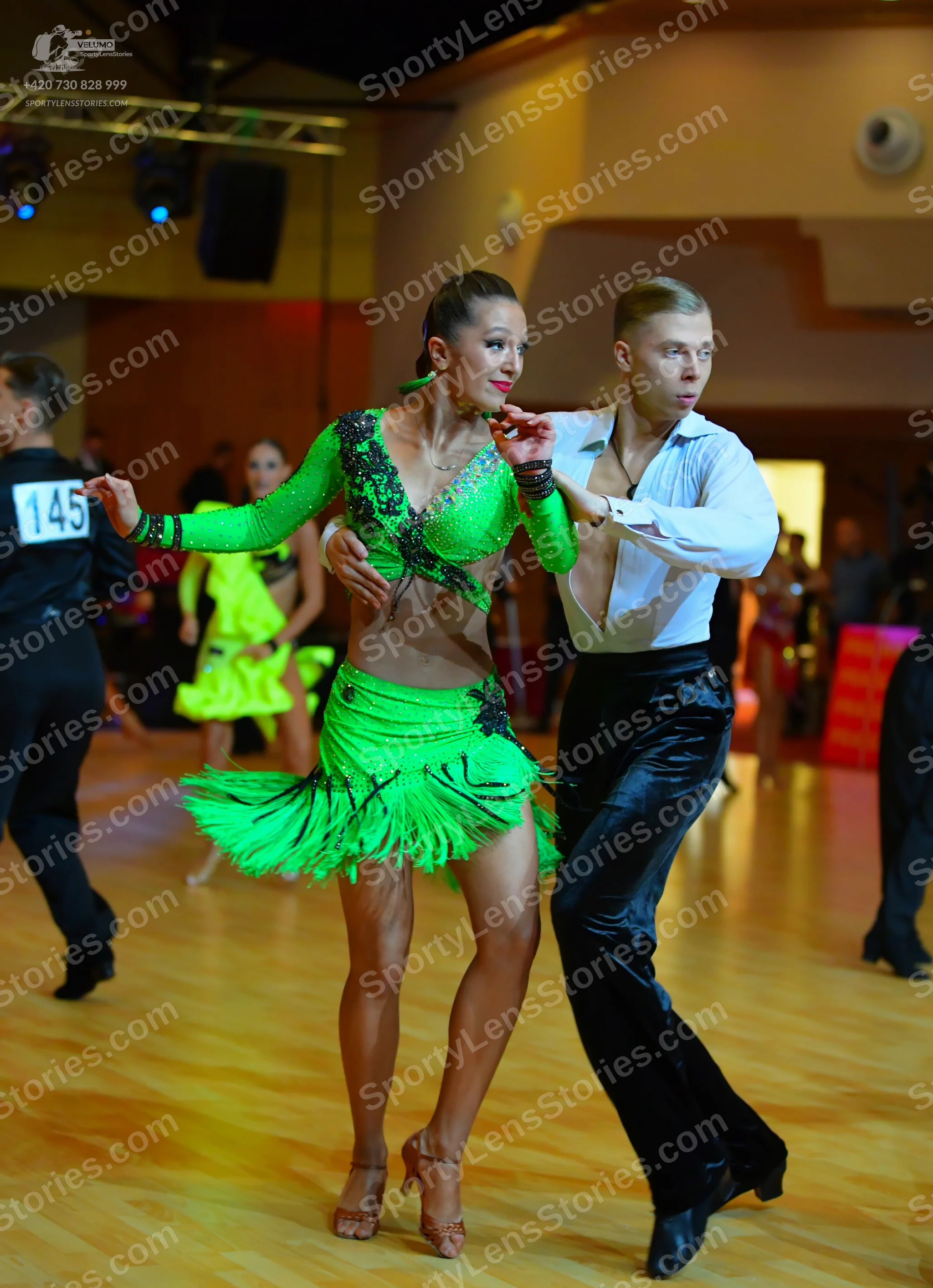 Dancesport competitor #145: Female dancer: bright green long-sleeved latin dress with black sequin embellish