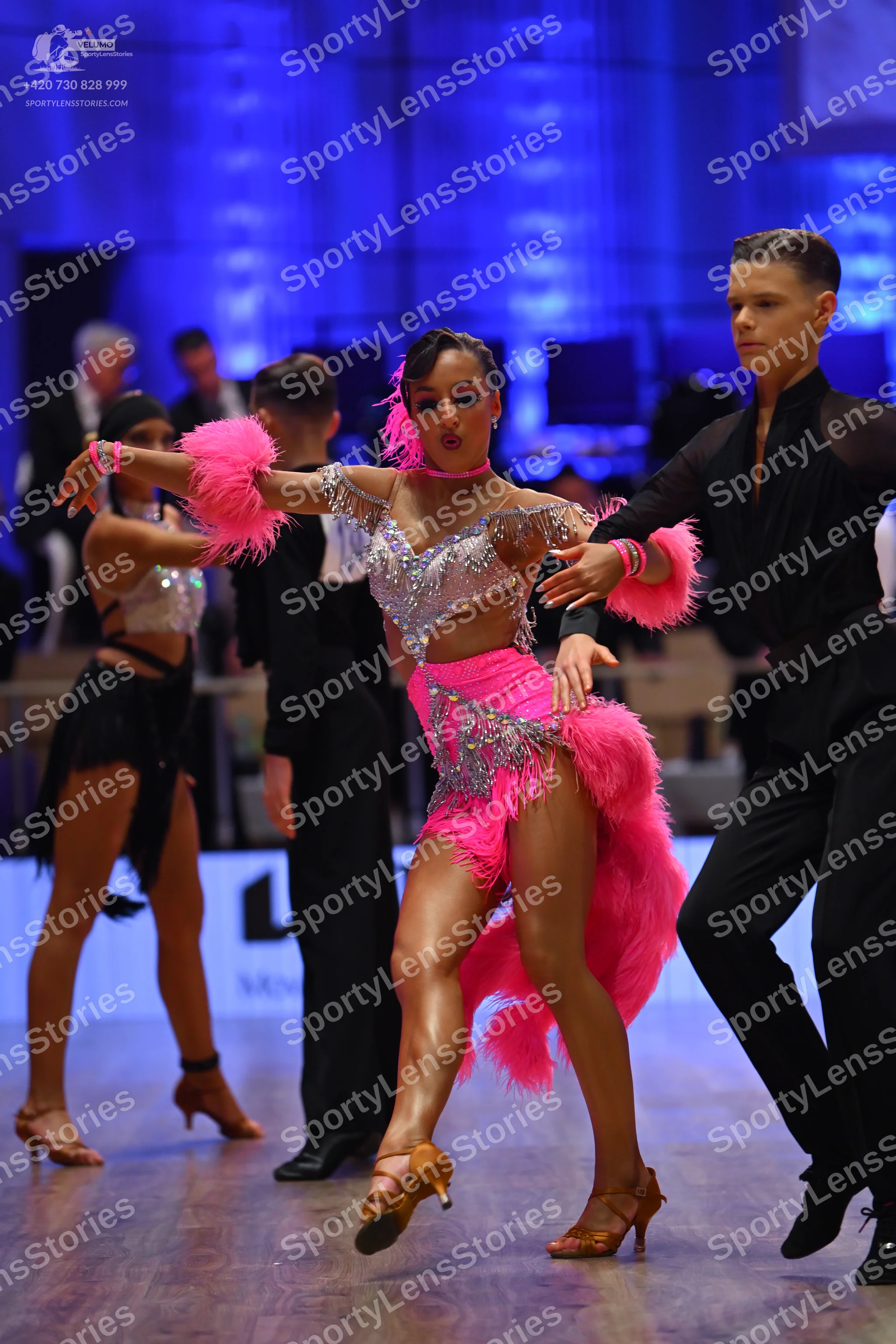 Dancesport competitor: Central female dancer: pink Latin dance costume with a silver sequined/rhineston