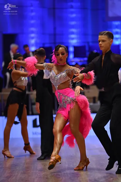 Dancesport competitor: Central female dancer: pink Latin dance costume with a silver sequined/rhineston