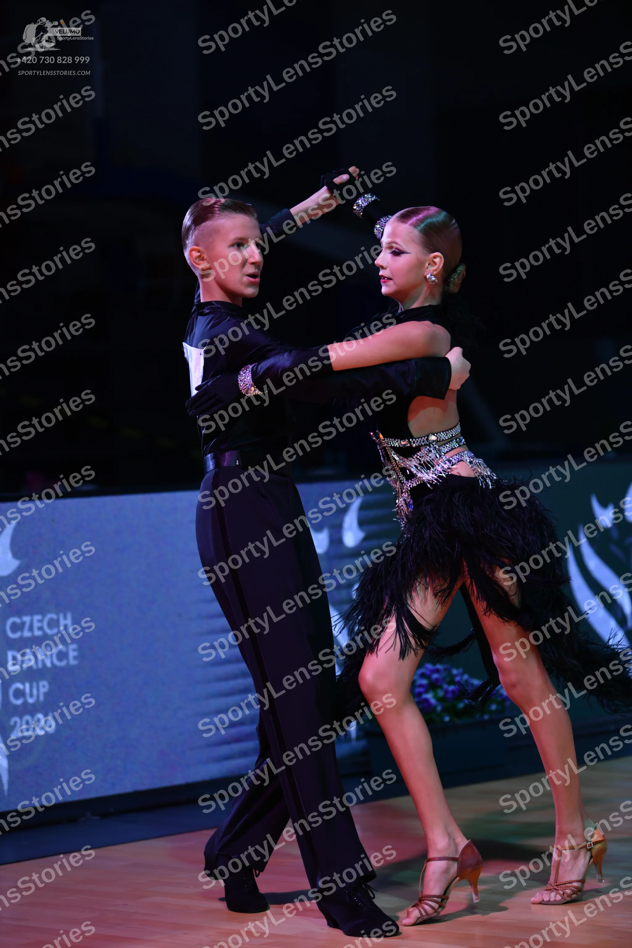 Dancesport competitor: Male dancer: black long-sleeved shirt with a white detail on the shoulder, black