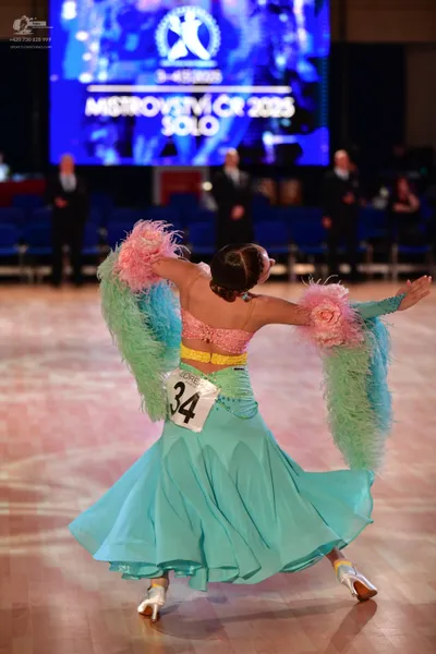 Dancesport competitor #34: Female dancer: light turquoise ballroom gown with a pink sequined bodice and lar