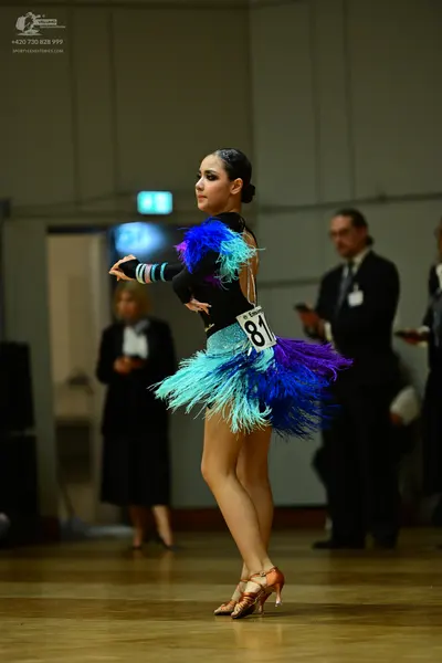 Dancesport competitor #81: Female dancer: black latin dress with blue and purple feathers/fringe and a turq