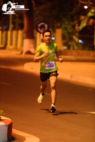 Marathon runner #42537: Runner 1: green jersey, black shorts, white shoes