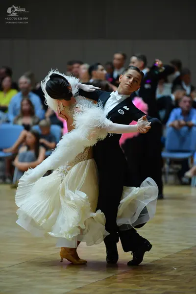 Dancesport competitor: Male dancer: black suit with a white bowtie and a small white logo on the jacket